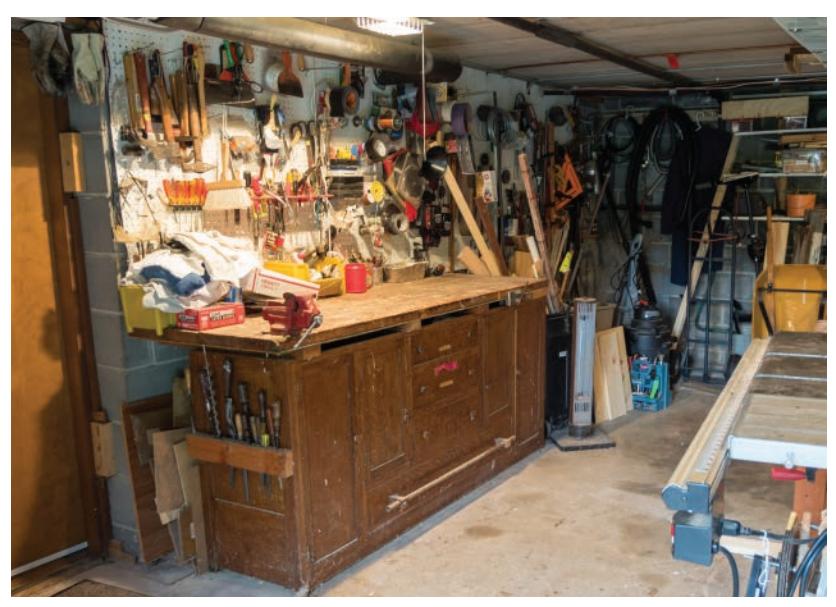 Cluttered small shop with repurposed dining room buffet as workbench