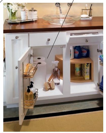 Open sink base with wall-mounted drain trap for storage