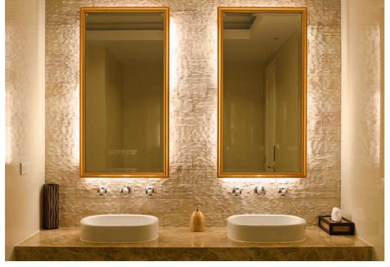 Bathroom with hidden lighting behind sink mirrors.