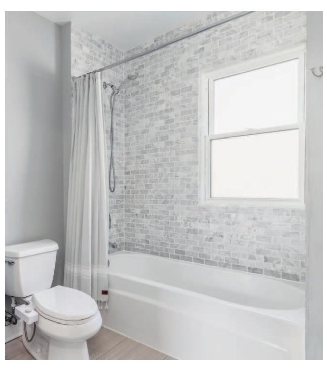 Traditional one-piece alcove tub with high-end surround tile.