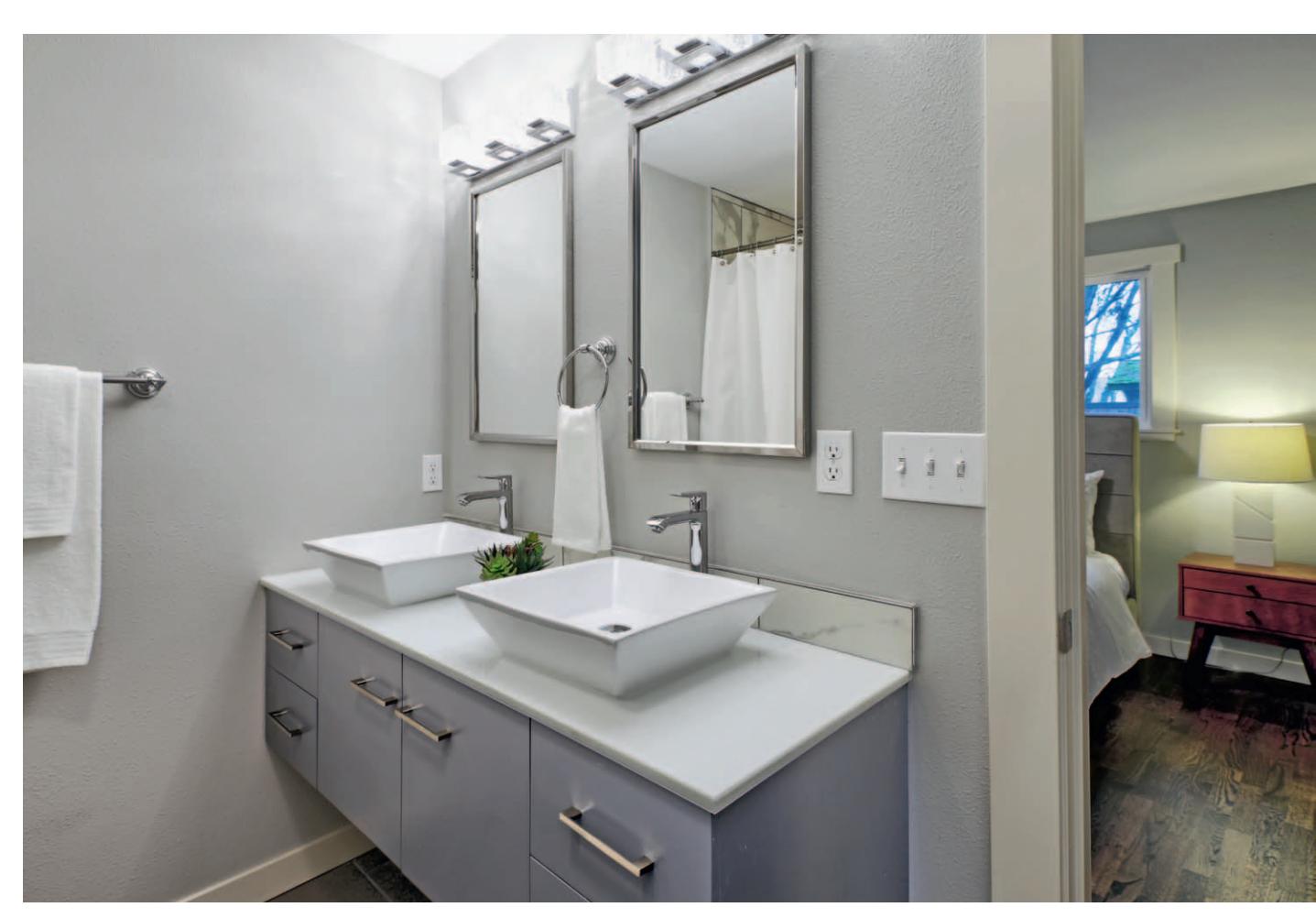 A stylish wall-mount vanity with two sinks and ample storage.