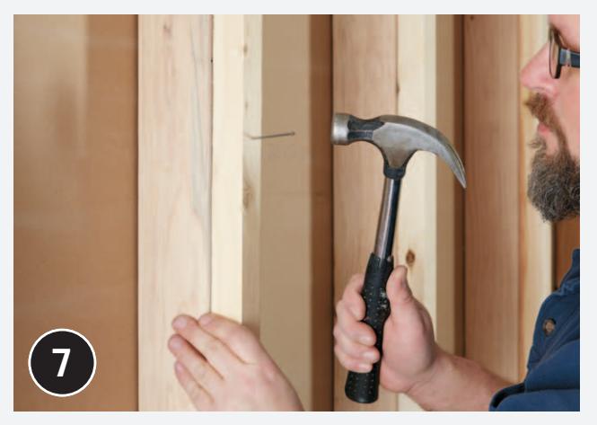 Attaching vertical furring strips to wall studs.