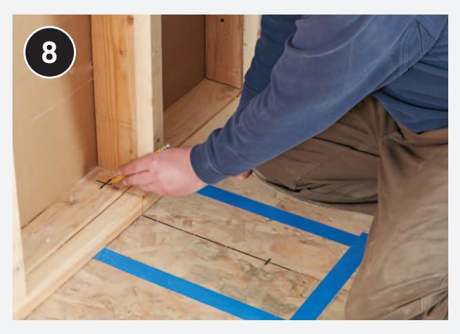 Marking drain locations on the subfloor and sole plate.