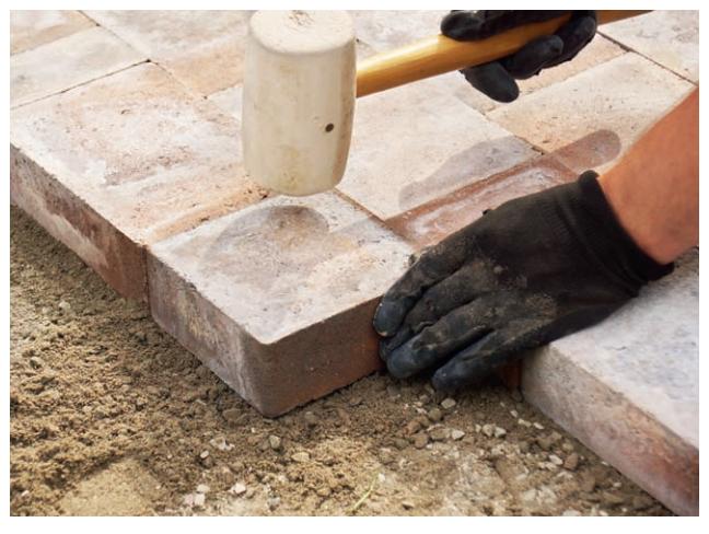 Concrete pavers set in sand offer a long-lasting, stable floor covering that breathes and allows for good drainage.