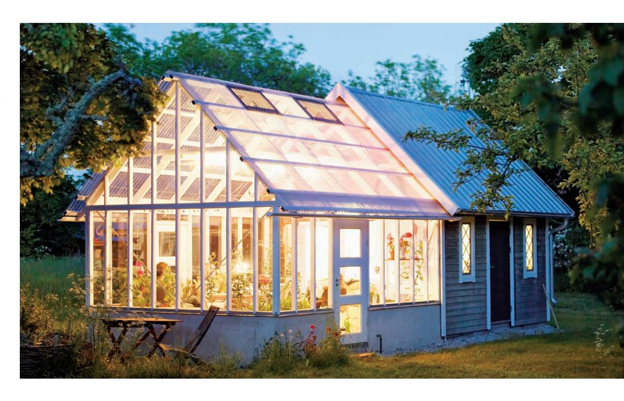 Fluorescent grow lights illuminating plants in a greenhouse.