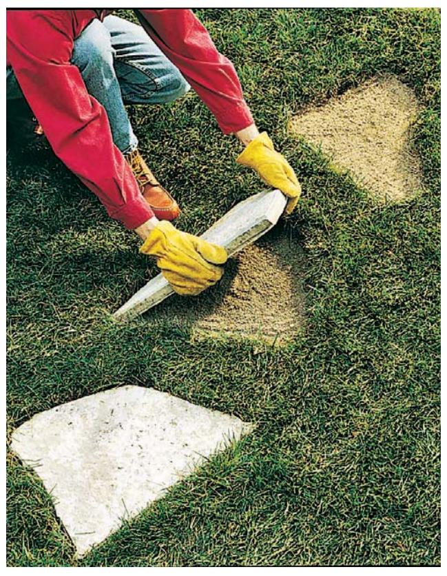 Placing a stepping stone in a sand-filled hole.