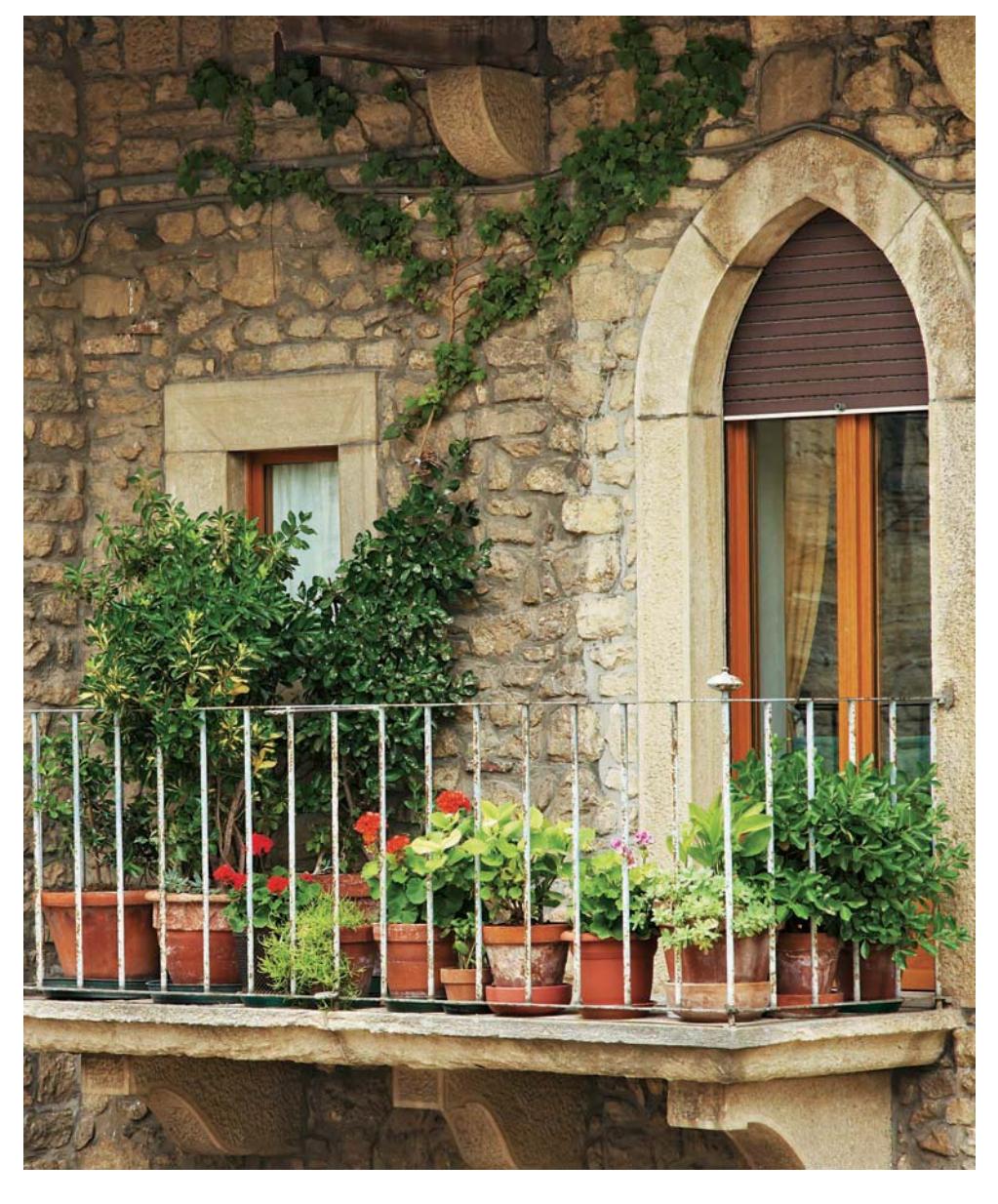 Balcony garden with plants in containers and hanging bags.