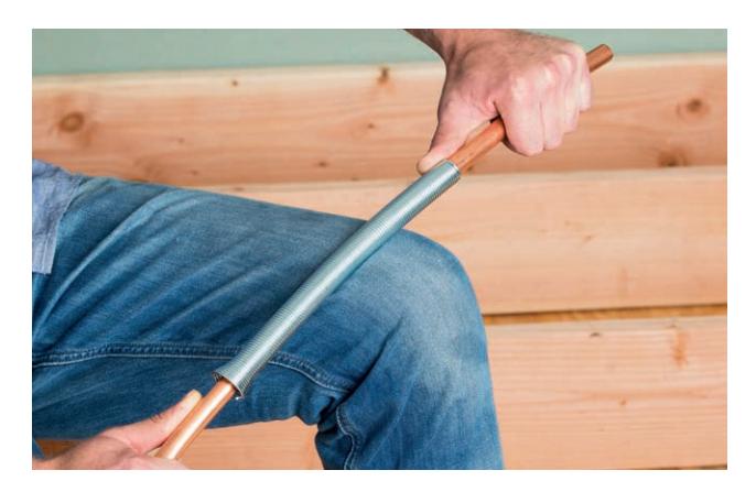Bending flexible copper pipe with a coil-spring tubing bender